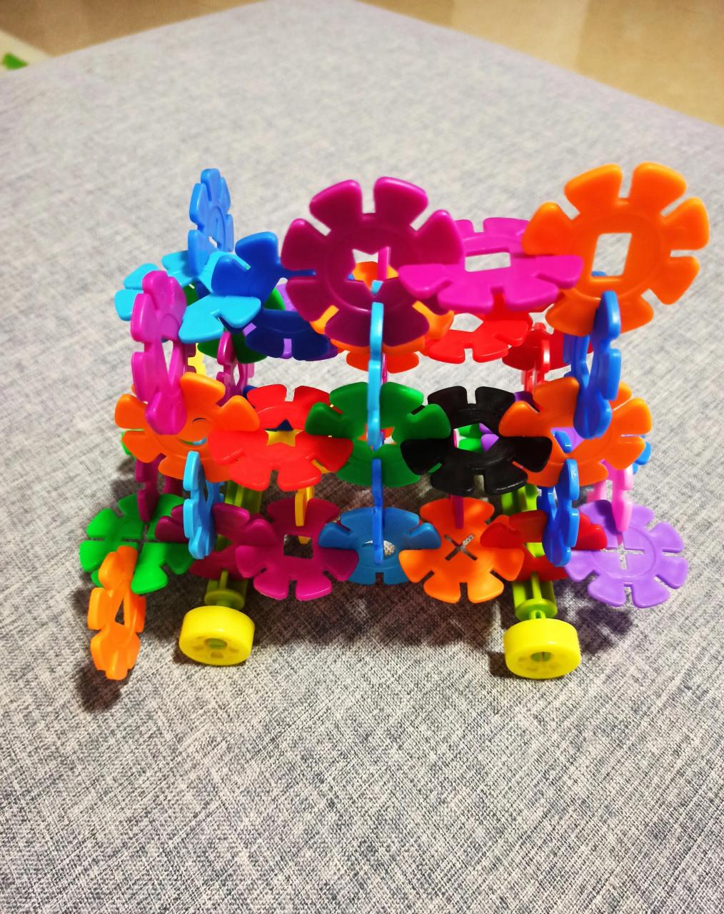 "妹妹手里拿着用雪花片拼的一辆车的造型走到我面前问我.