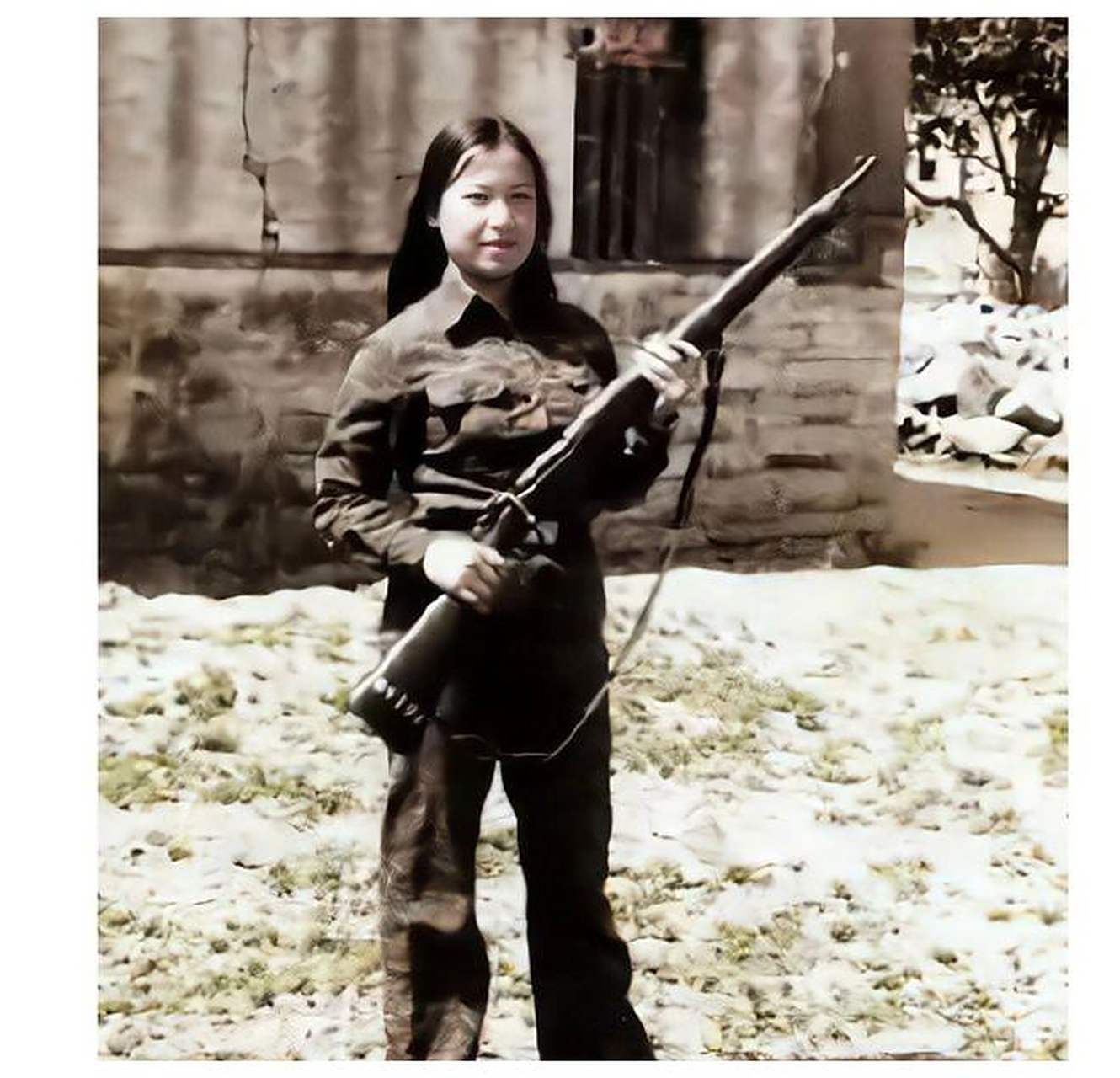 1952年,身穿军装和草绿色军裤的国军女兵,站在金门岛上警惕地注视着