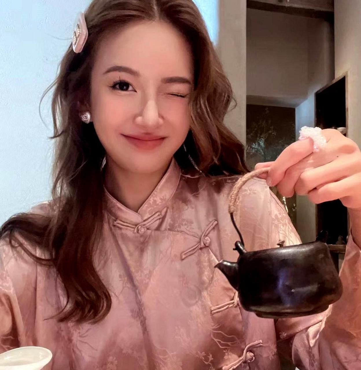 张子萱在喝茶时不忘自拍,连续切换三种表情,展现出与