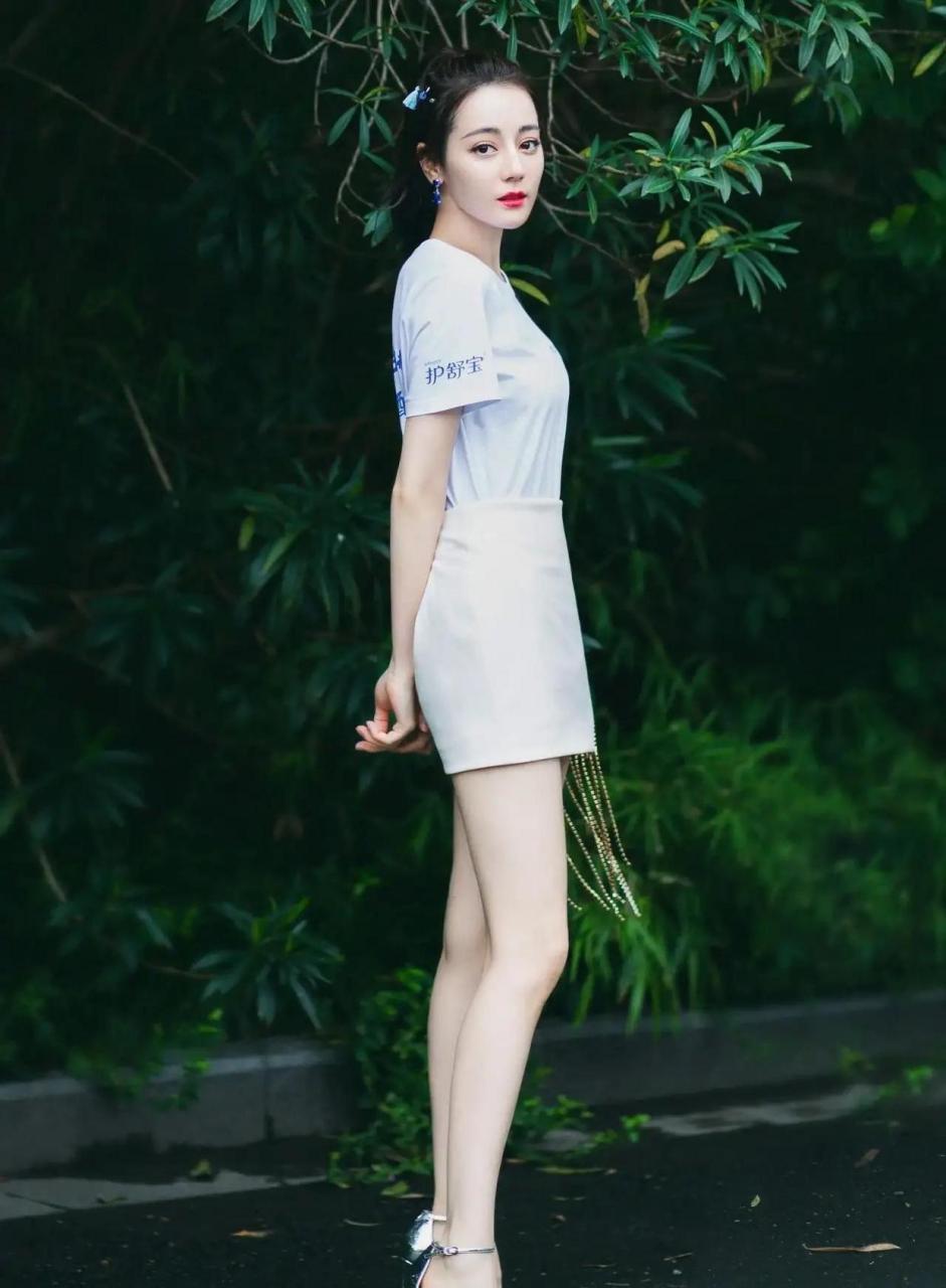 迪丽热巴代言护舒宝,白色超短裙配高跟鞋玉腿修长