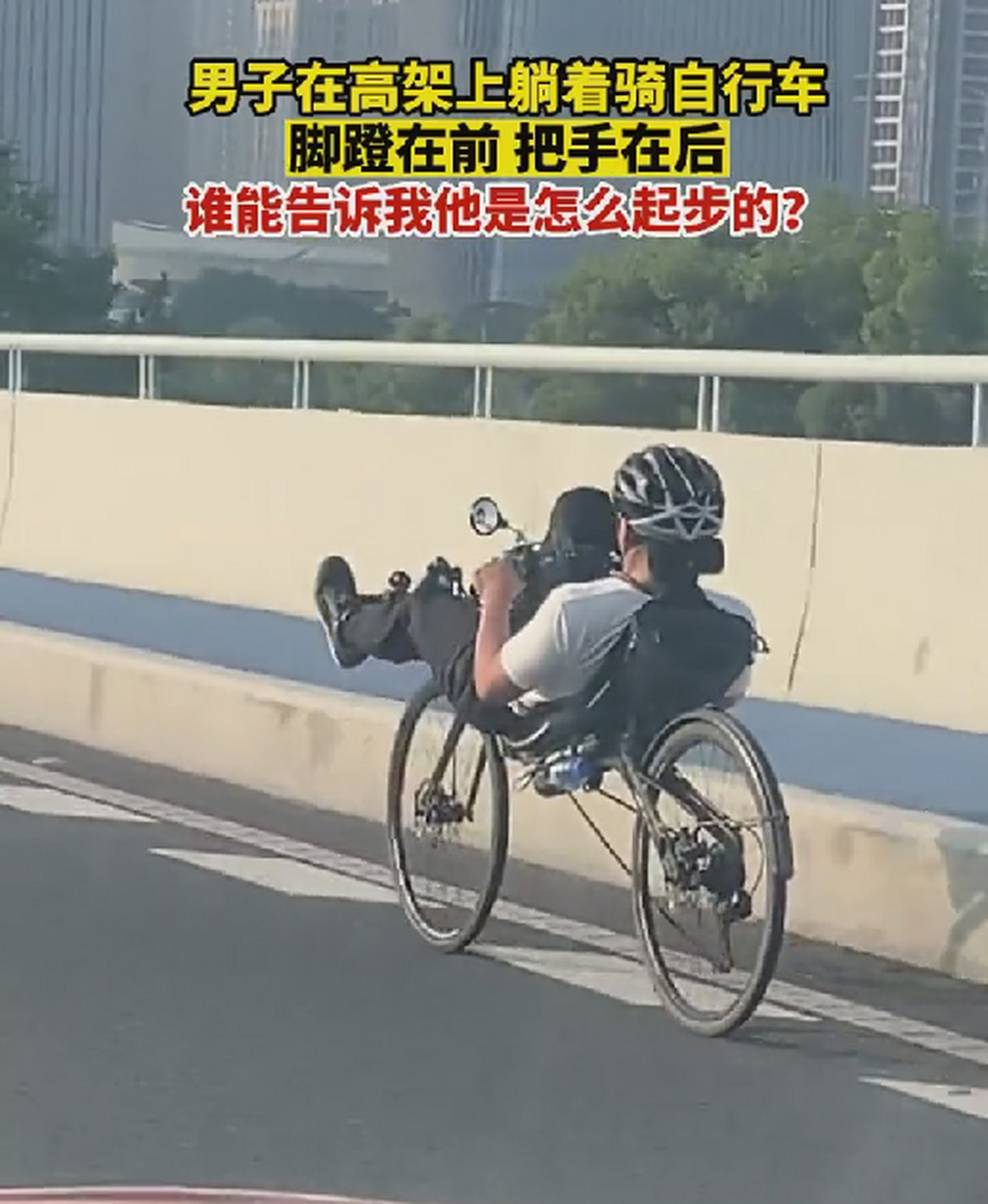 男子在高架上躺着骑自行车