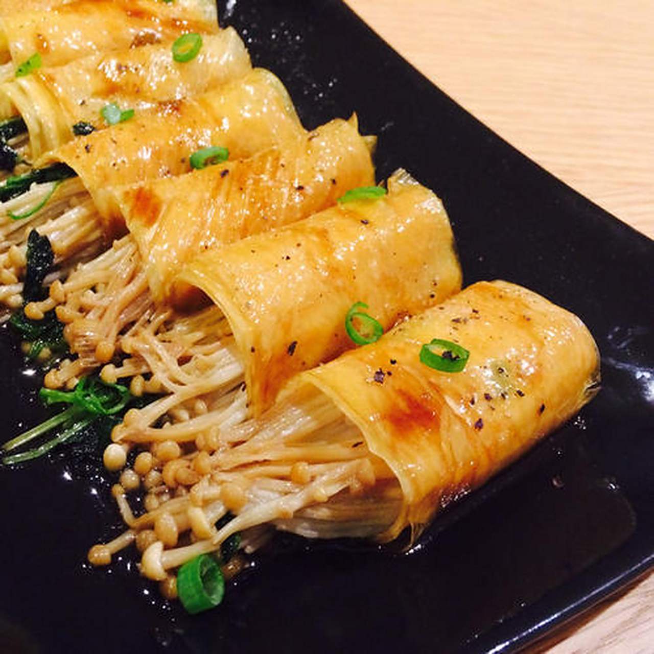 金针菇豆皮卷:金针菇洗净去根部,豆腐皮切条,卷起金针菇,上锅蒸熟