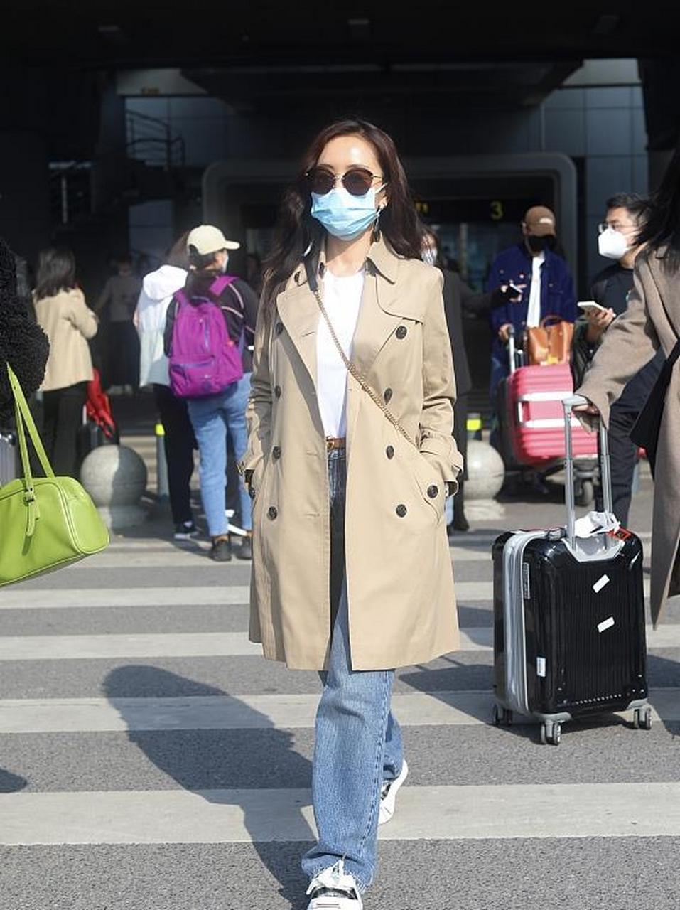 杨蓉街拍,她穿了一件卡其色的中长款风衣,内搭白色的圆领针织衫,搭配