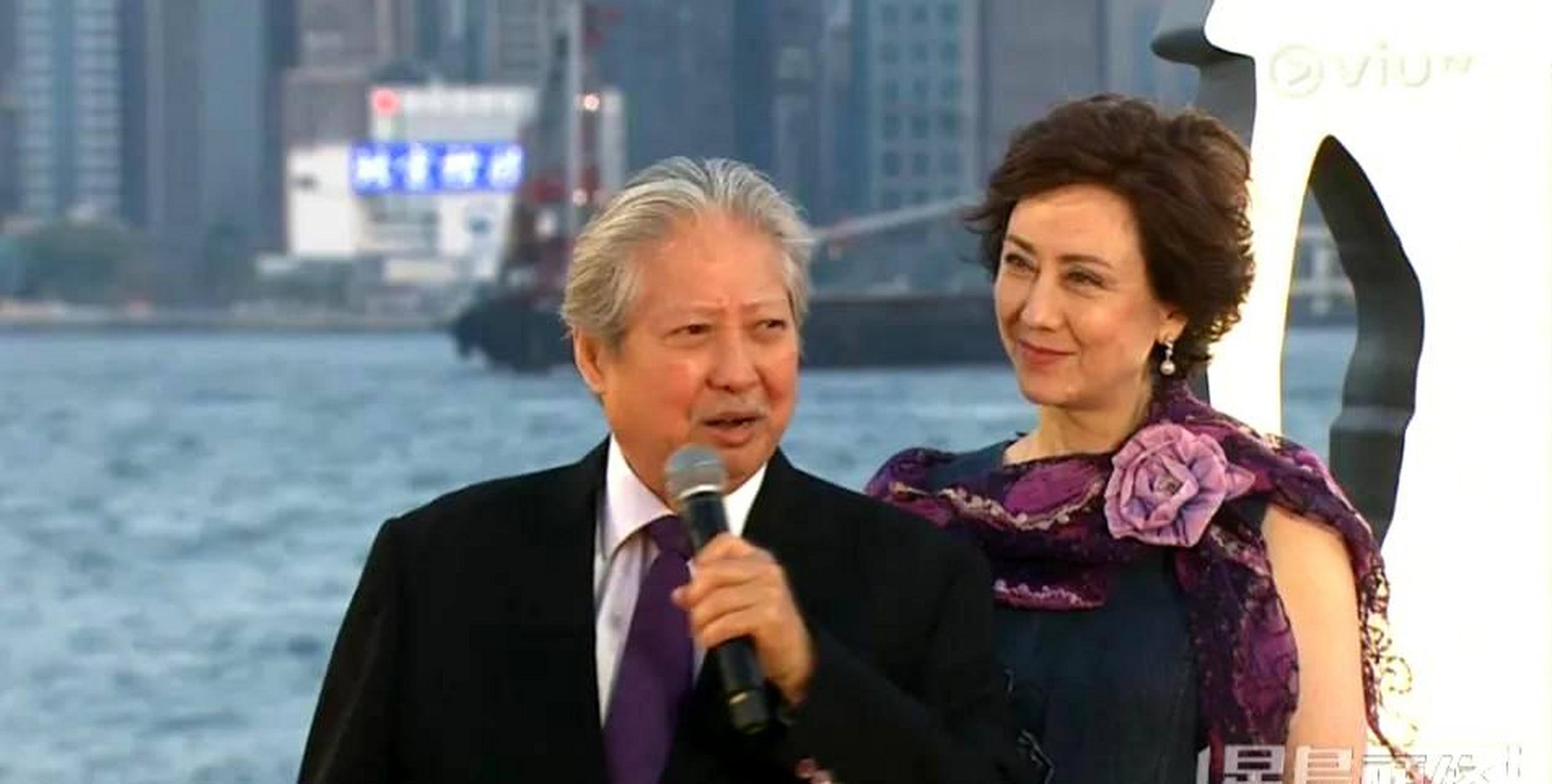 洪金宝身穿黑色西装搭配紫色领带,而高丽虹则穿着深