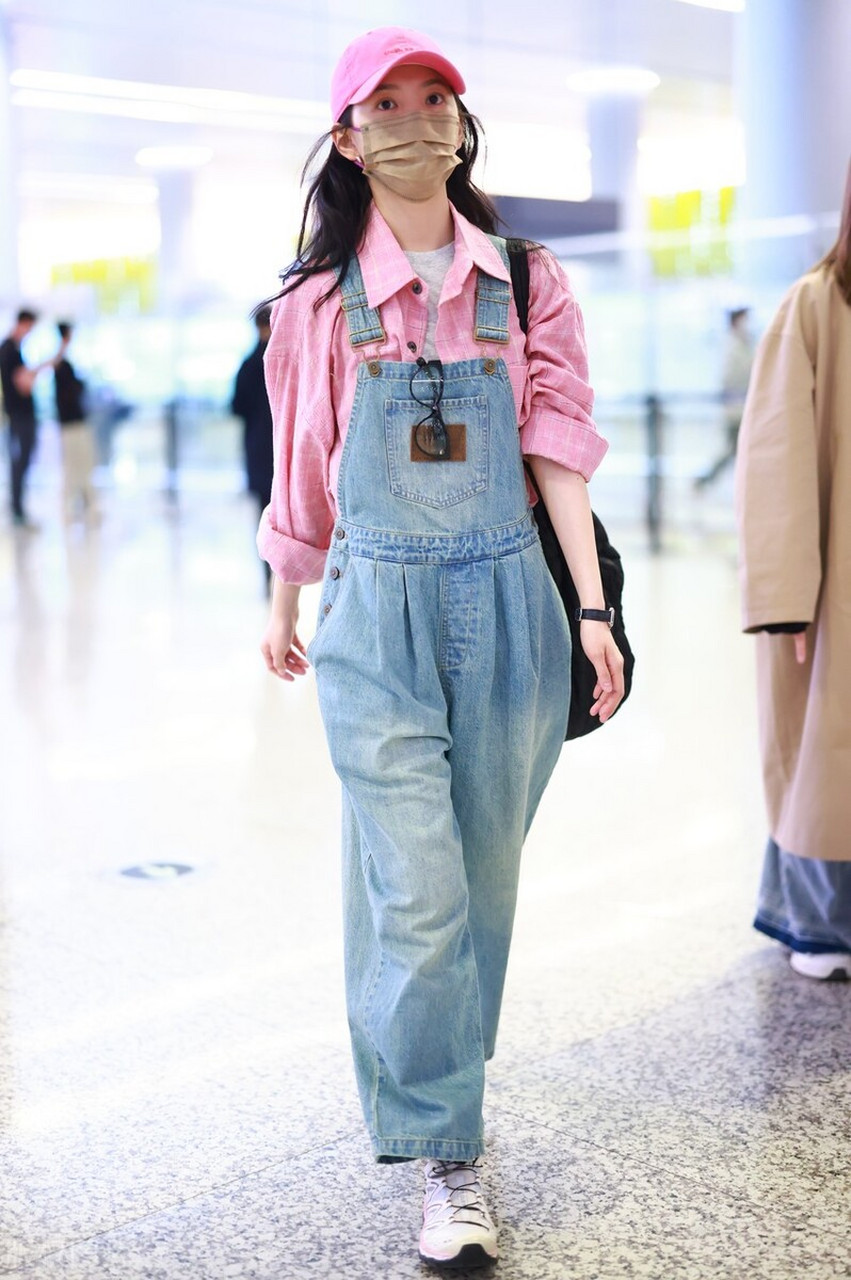 章若楠机场街拍,粉色衬衫搭配背带牛仔裤,棒球帽运动鞋青春可爱!