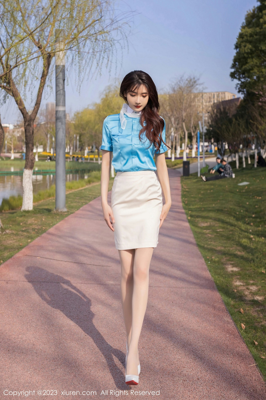 那位美女模特上身穿着一件淡雅的蓝色衬衫,衬托出她雪白的肌肤,显得