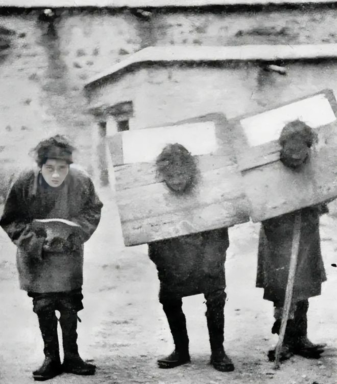 这是旧西藏的50年代初,几个农奴戴着沉重的铁枷,满脸忧愁地看着镜头.