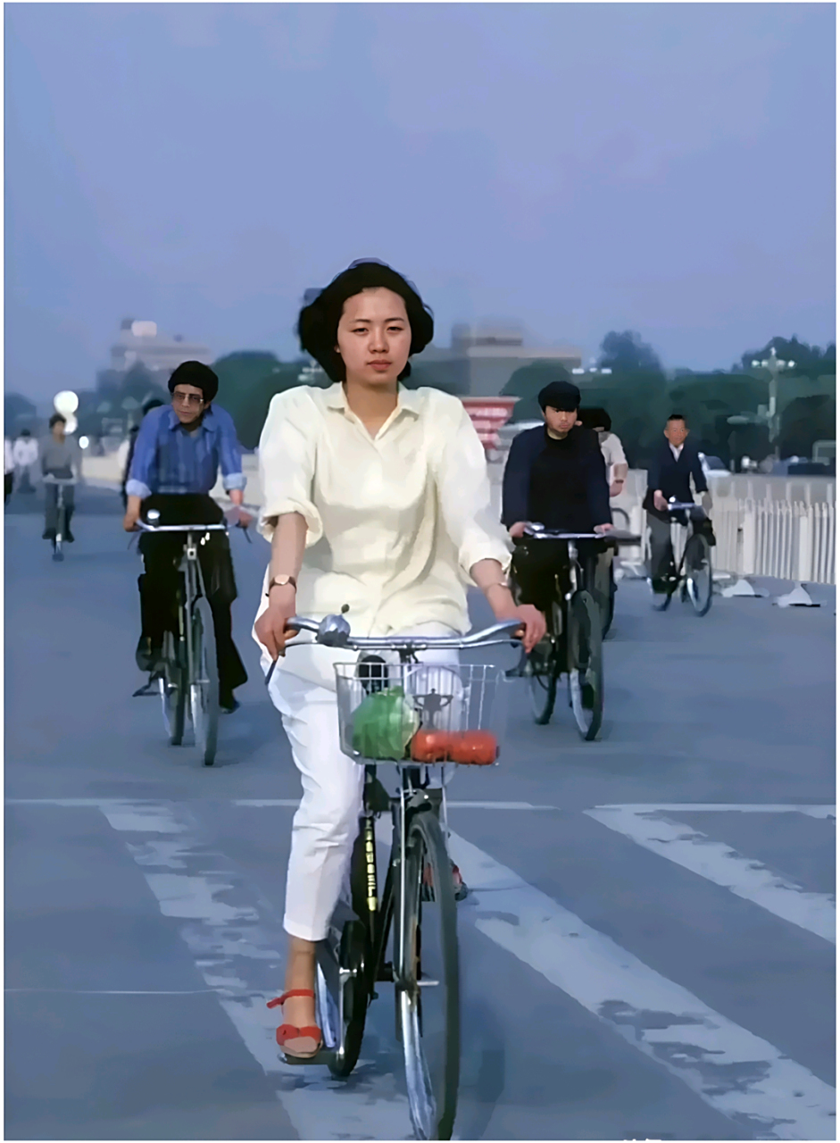 在整洁的道路上,她惬意的骑着当时实行的大梁自行车,车篮里放着新鲜