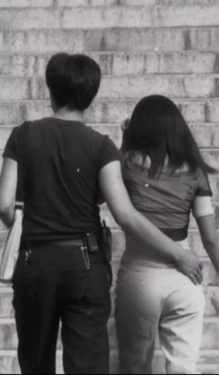 90年代,一对小情侣走在街头,从背影来看,小伙子腰上别着一台bb机和一