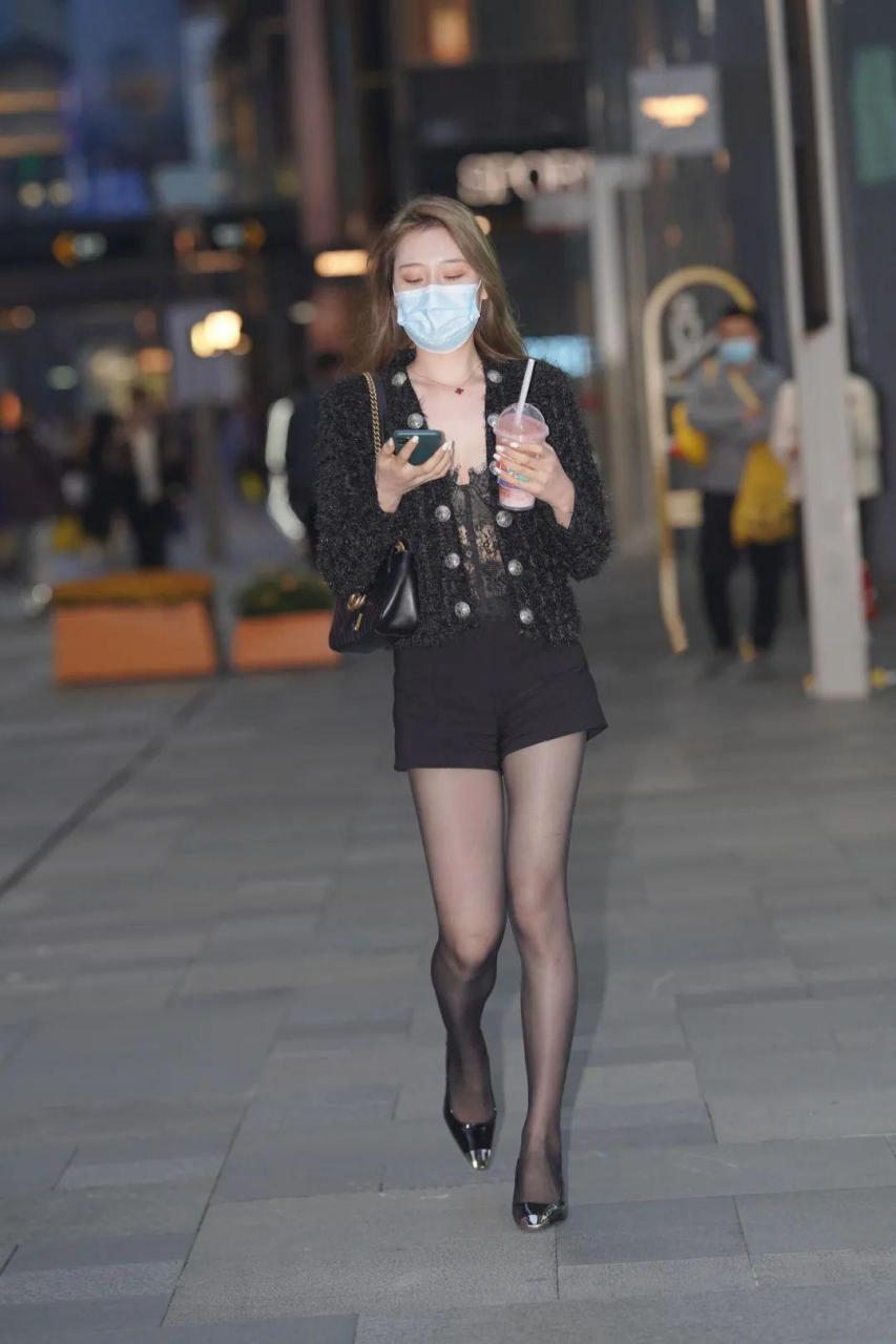 穿黑色短裤搭配黑丝高跟鞋秀长腿的时尚靓女