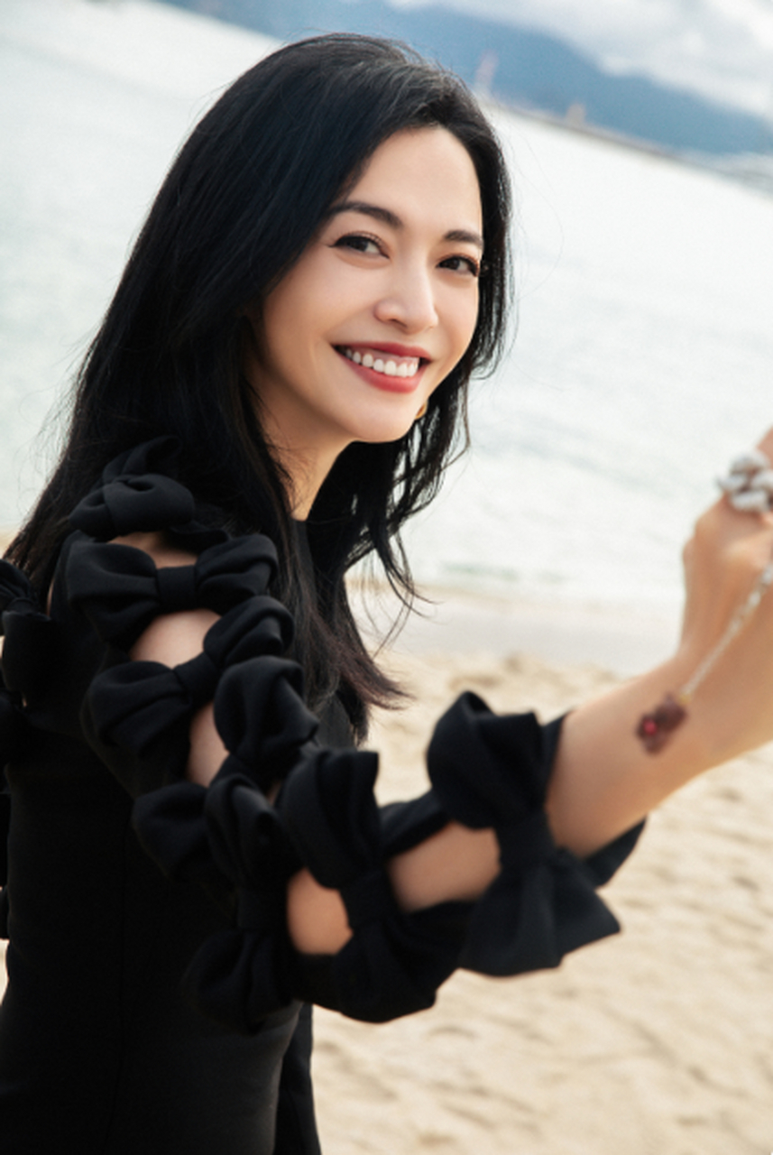 姚晨在戛纳海边的随拍中身穿黑色蝴蝶结开叉连衣裙,凸显了她的身材