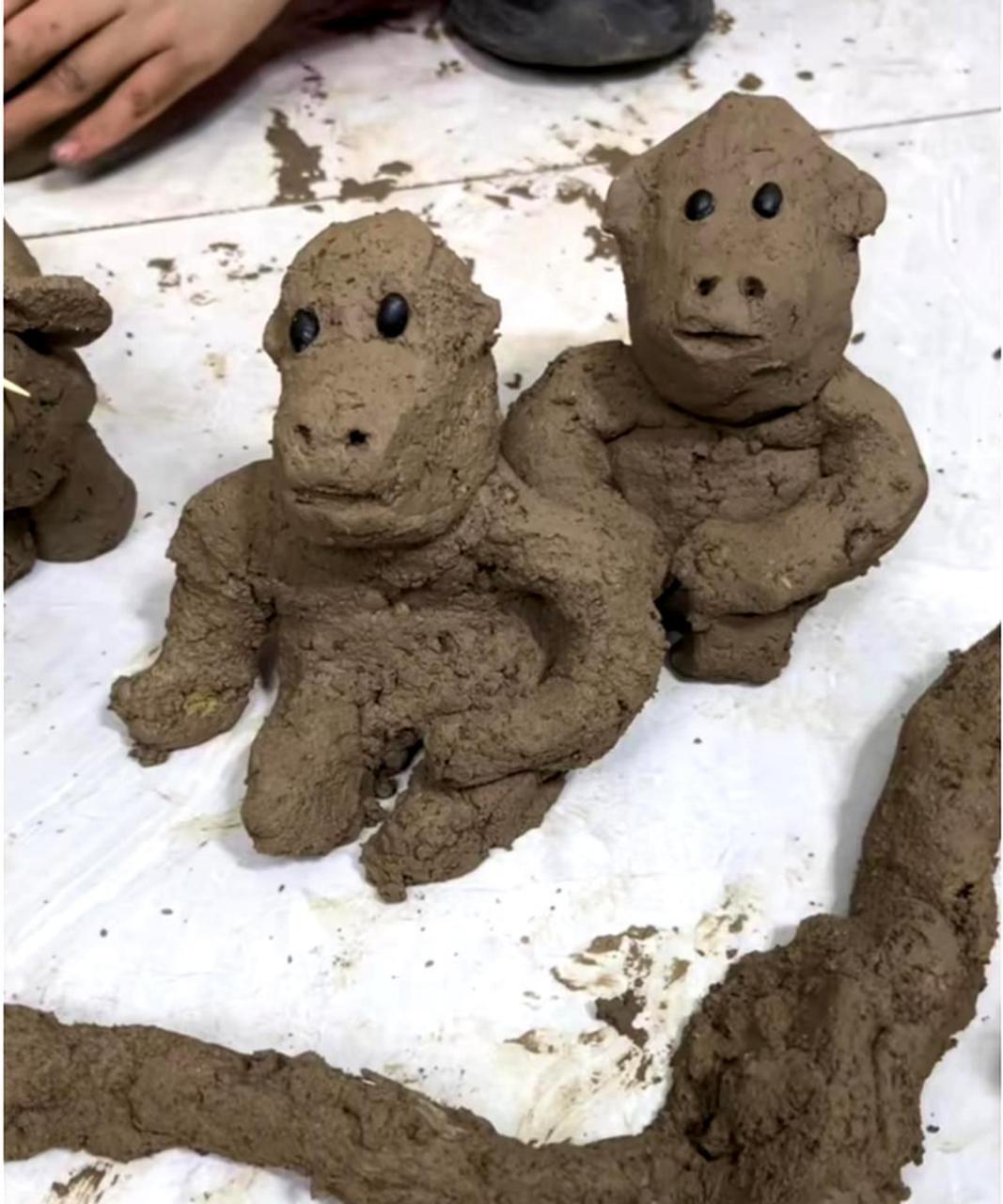 我家儿子用泥巴捏了一个动物园,其中大猩猩和鳄鱼的形象非常逼真.