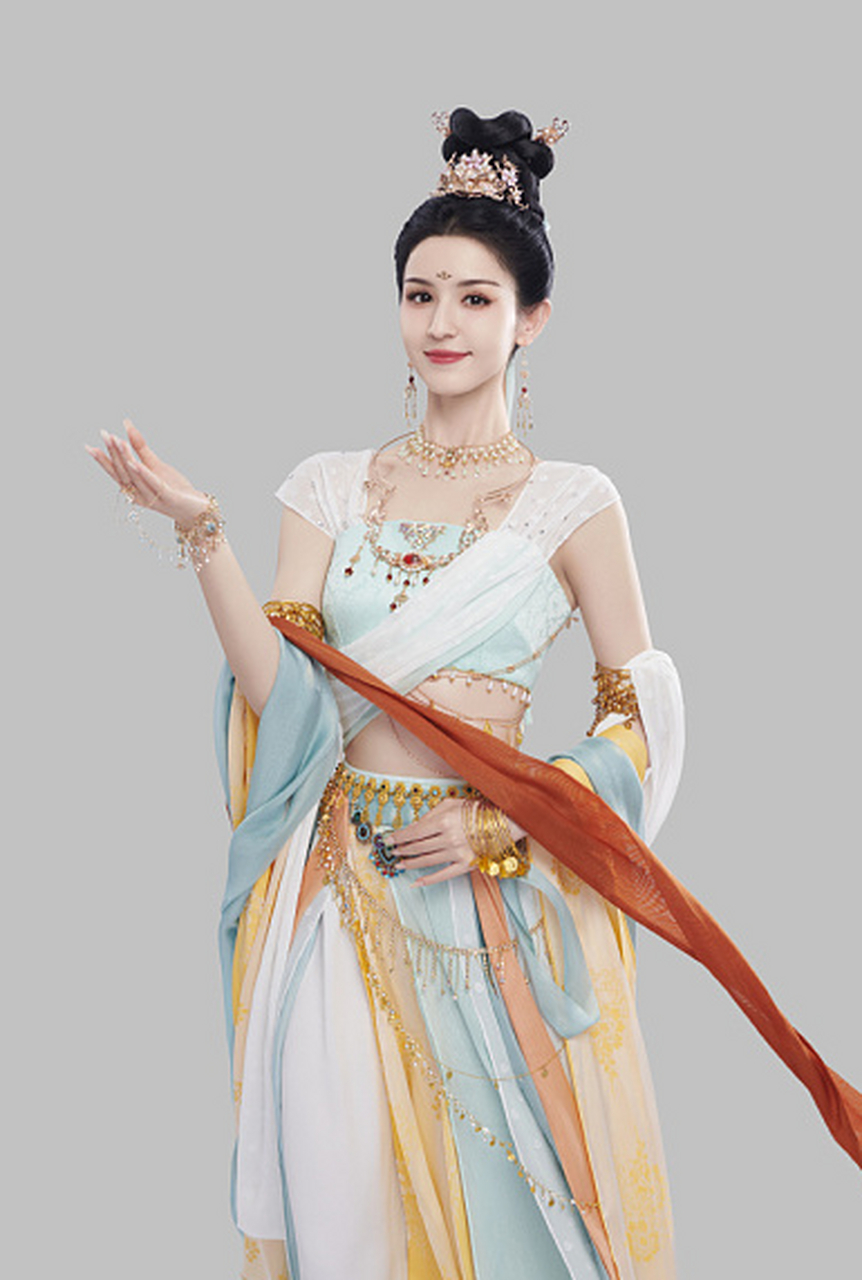 长裙仙气飘飘  哈妮克孜身穿一袭白色长裙,头戴金色发饰,手持飞天翅膀