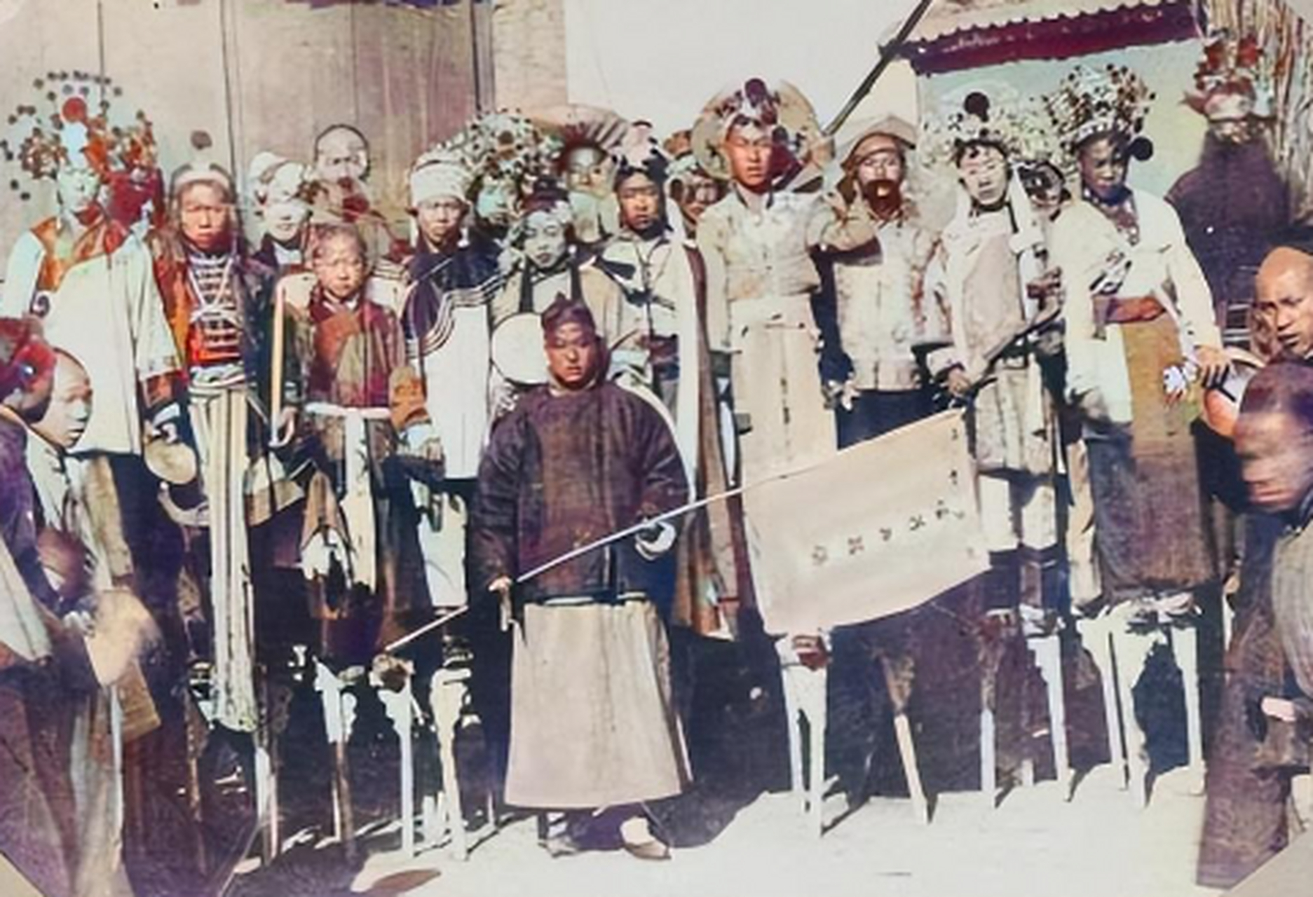 照片中拿着旗子的是班主 拍摄时应该是刚到一个新地方,演员们踩着