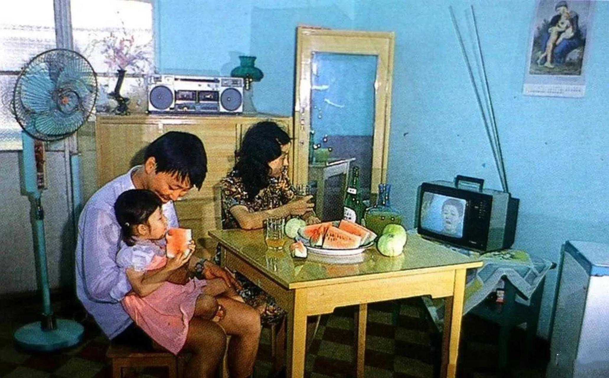 上世纪90年代,一个三口之家正在看电视.