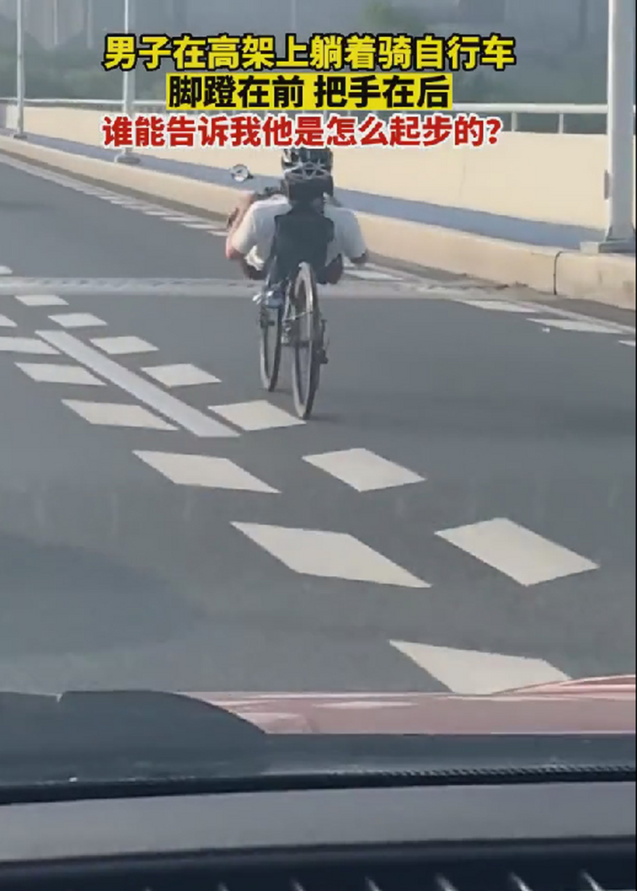 男子在高架上躺着骑自行车