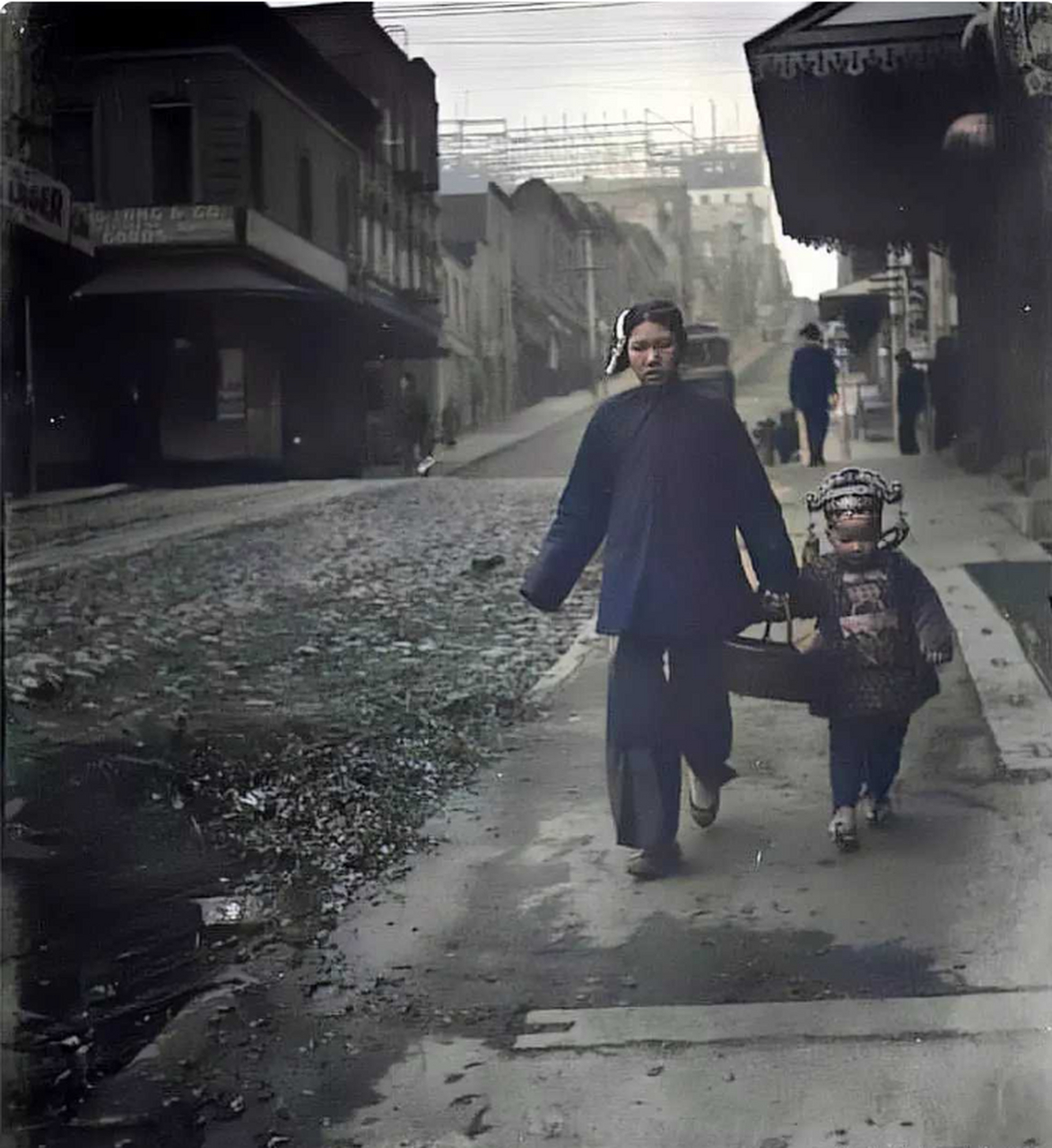 1906年,旧金山的唐人街,一位妈妈带着身着祖国传统服装的孩子走街串巷