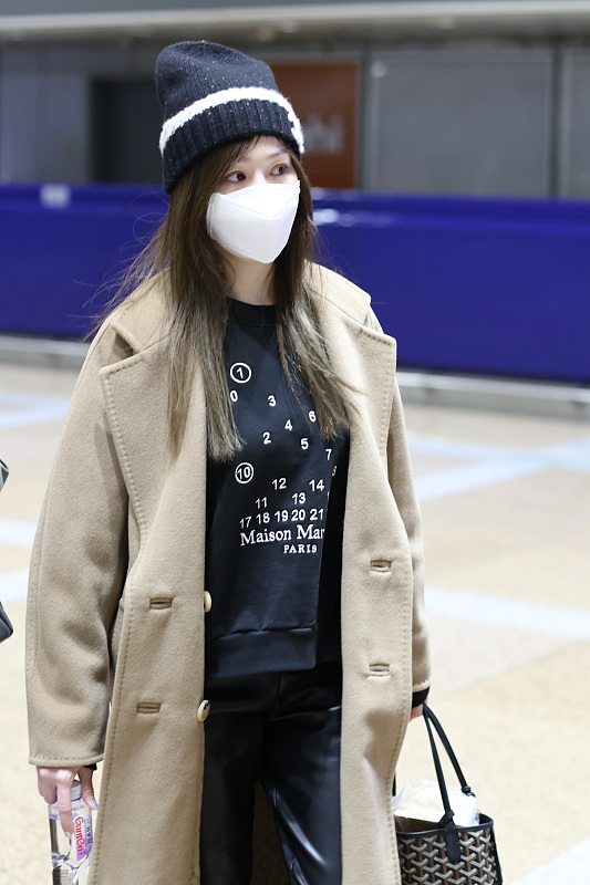 王心凌最新机场照来了,她戴了一顶黑白印花的针织帽子,穿一件卡其色的