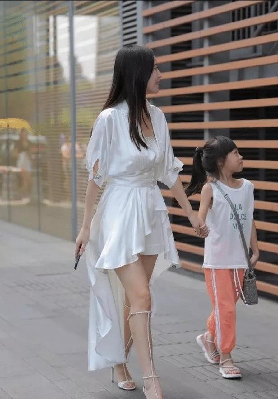 穿着纯白色丝绸长短裙的超级辣妈