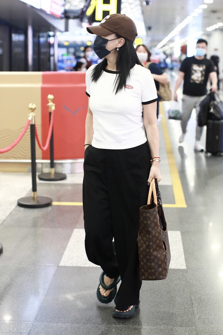 机场街拍 那英现身机场.头戴棒球帽身着白色t恤黑阔腿裤休闲随性.