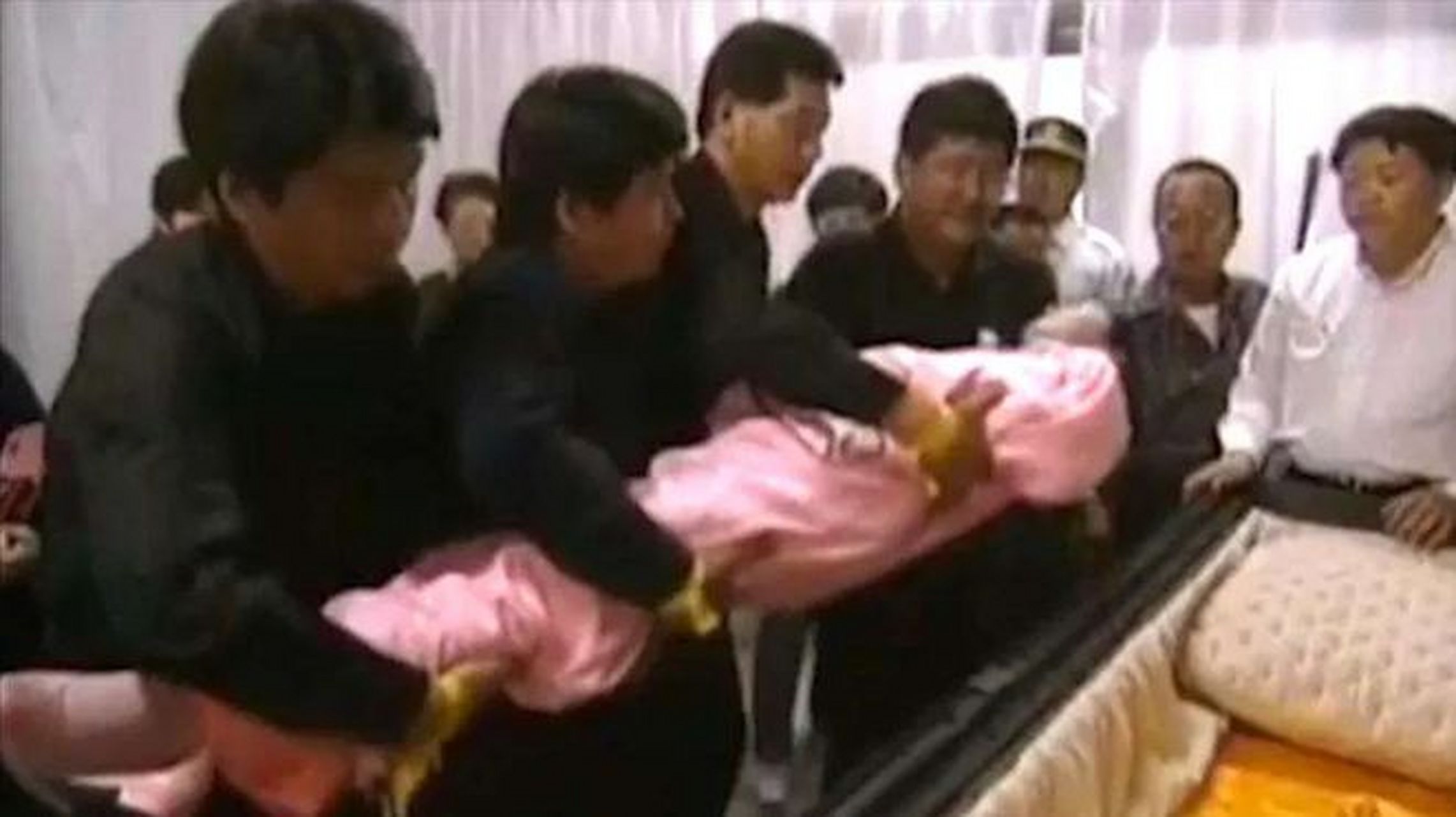 1995年,邓丽君的遗体被缓缓地放入水晶棺中,这一幕被摄影师抓拍下来