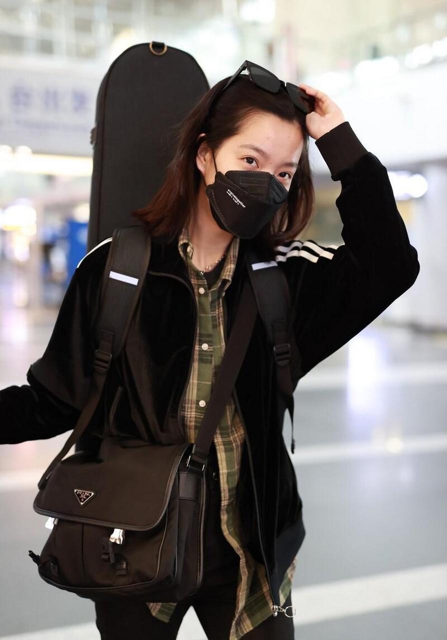 庄达菲机场街拍,黑色运动服搭 铅笔裤,背吉他酷飒十足