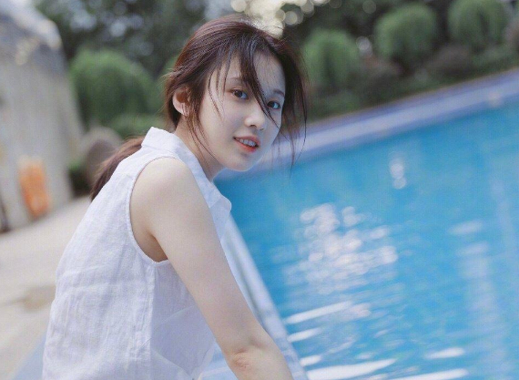 张慧雯光着小脚丫坐在泳池边,宛如一道美丽的风景线.