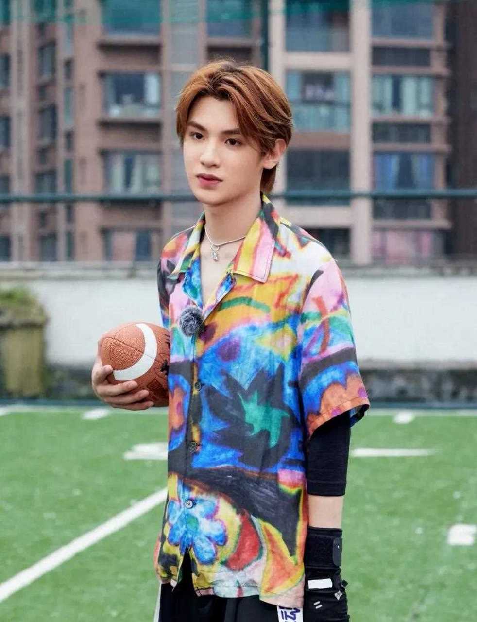 黄明昊参加综艺的穿搭造型,一身彩色印花衬衫,内搭白色v领t恤衫,再