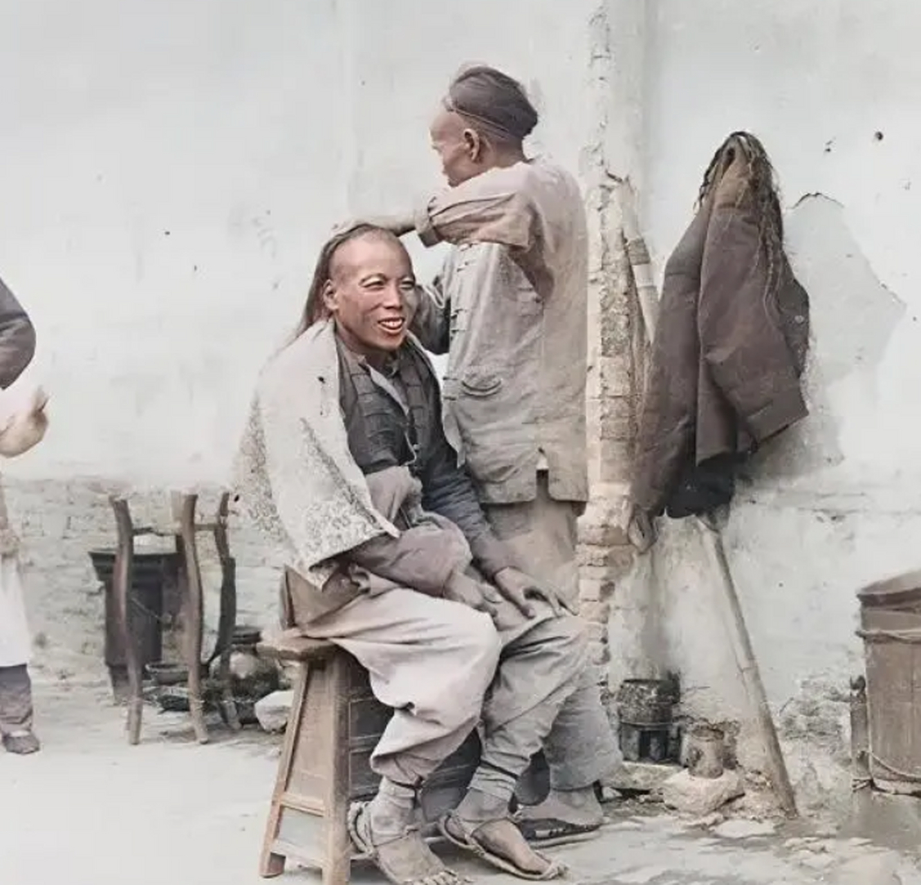 清朝老照片:这是拍摄于清朝末年的照片,正在理发的男子脸上露出了非常