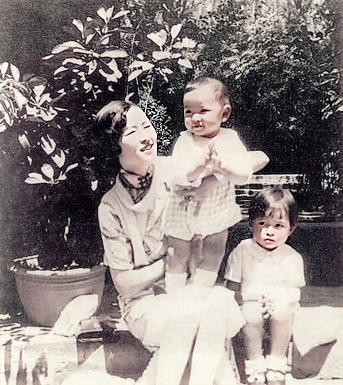 1932年,林徽因怀抱刚出生的儿子梁从诫的照片,而一边还站着女儿梁再冰