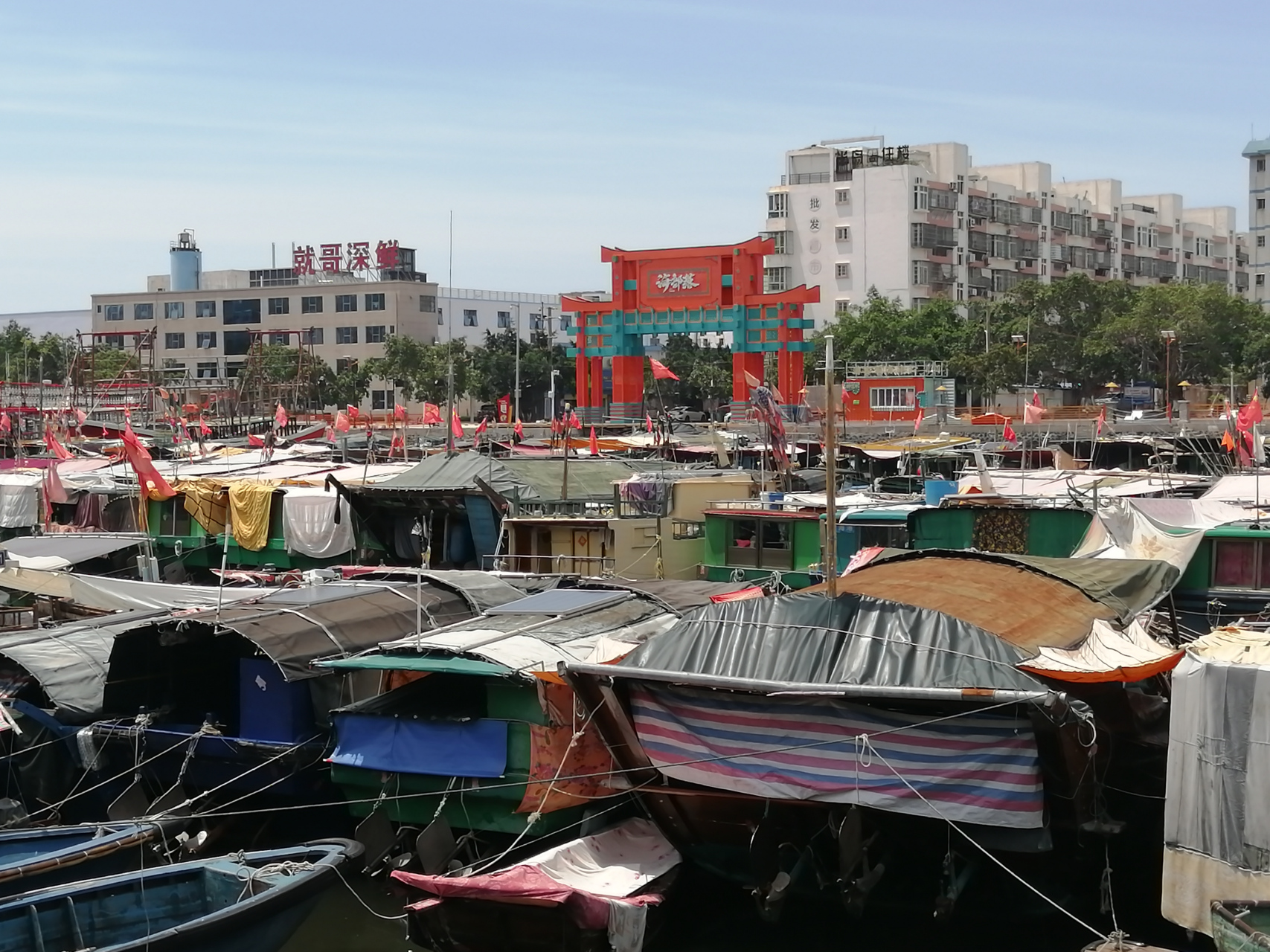 北海市侨港镇的内港停了很多渔船,望不到头,旁边的马路对面是一排大