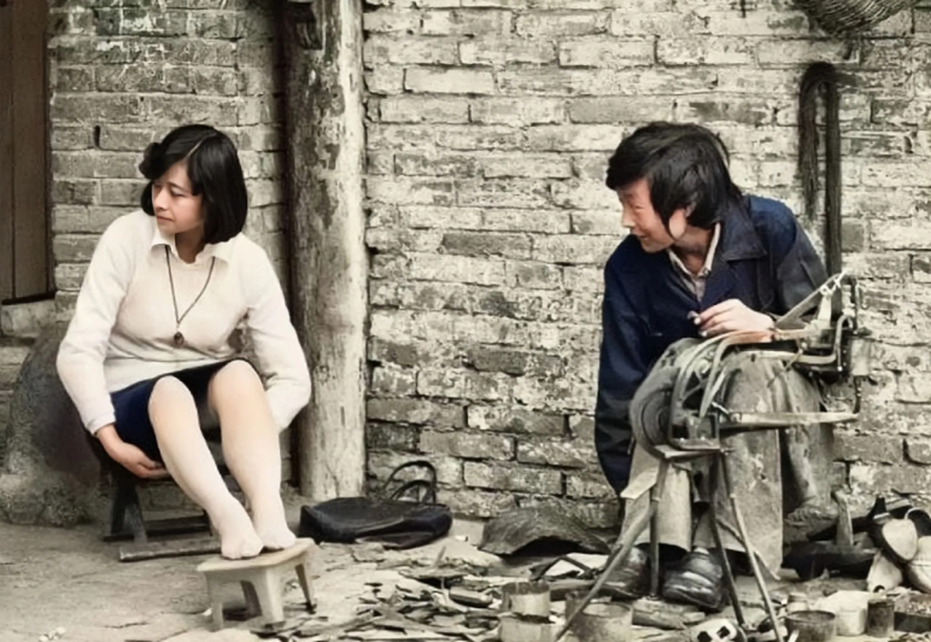 这张照片拍摄于上个世纪八十年代,一个小姑娘正在鞋摊修鞋,这个小姑娘