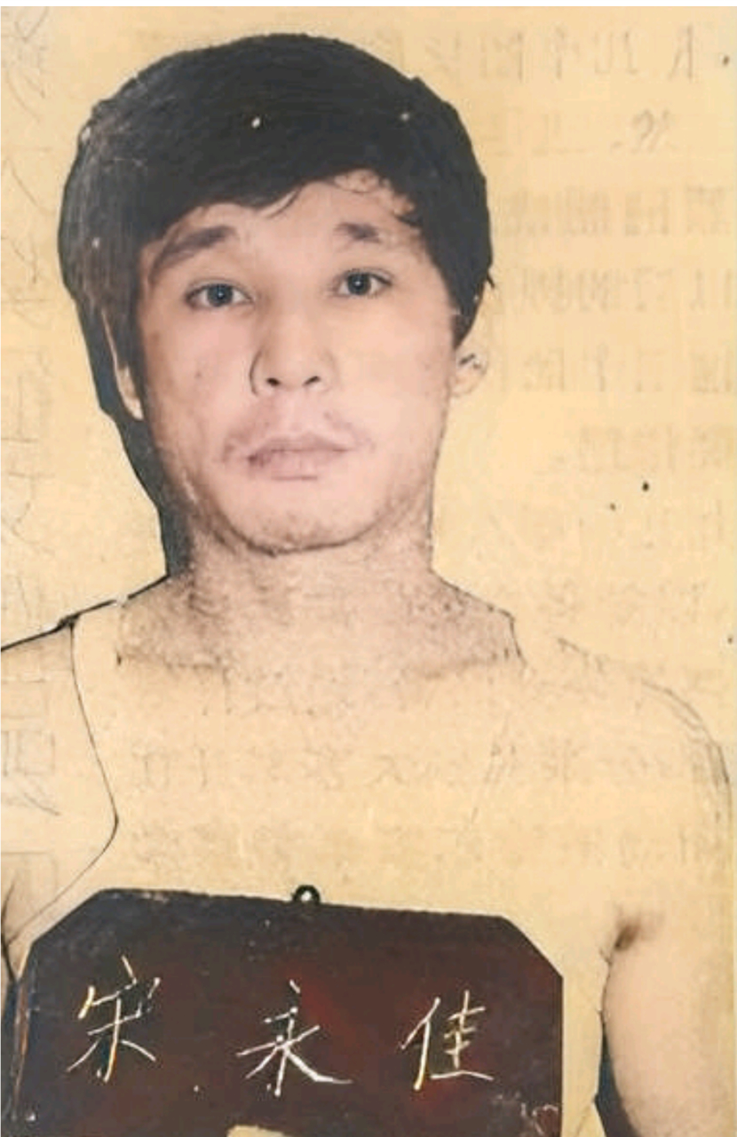 1990年,"乔四"宋永佳被捕后的情景,画面中的他举着自己的名牌面对着