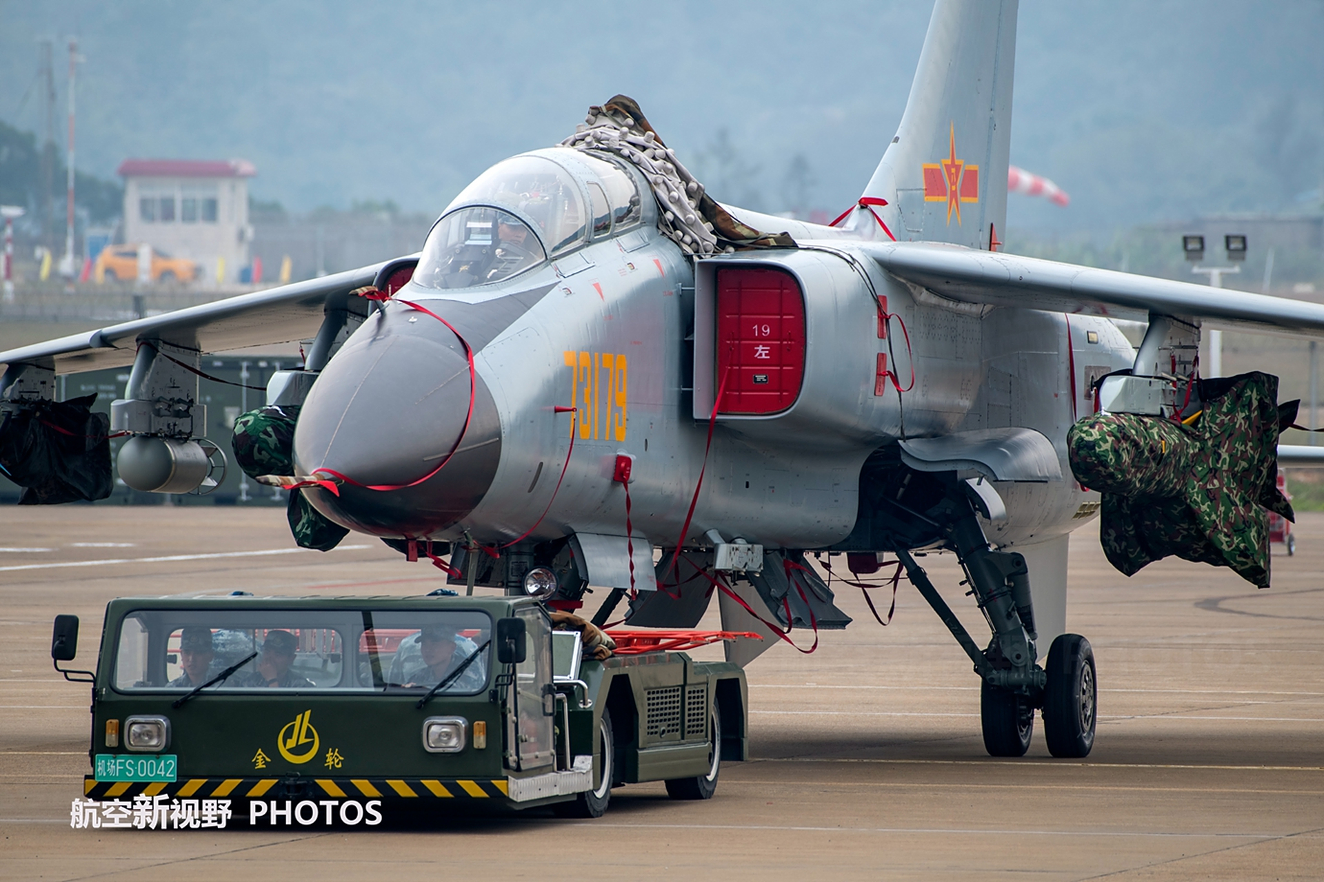 我国空军歼轰-7战斗机在不同的地方,使用不同的牵引车.