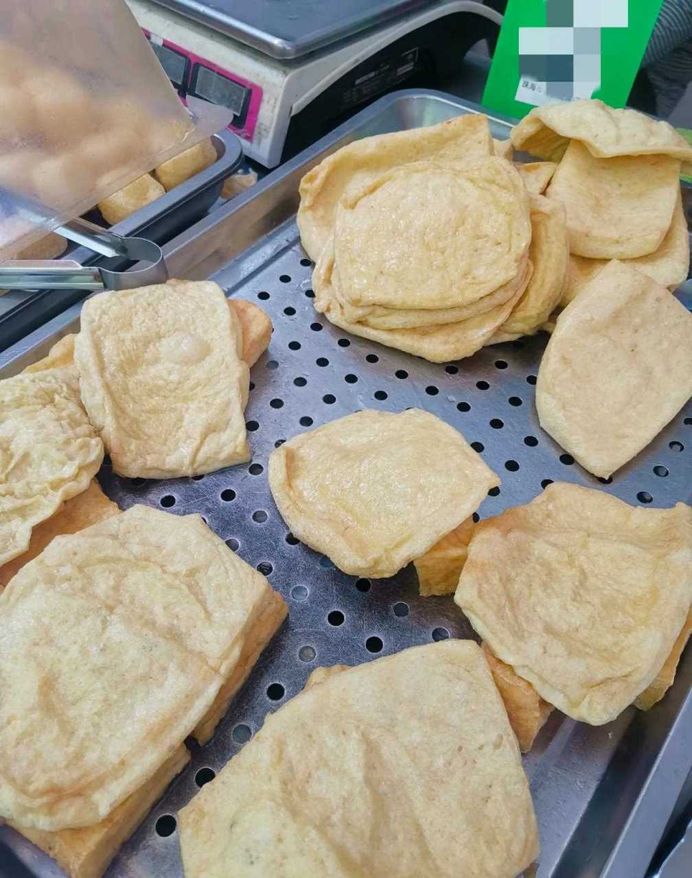 市场豆腐店刚出锅的炸豆腐皮,把炸好豆腐皮切成丝