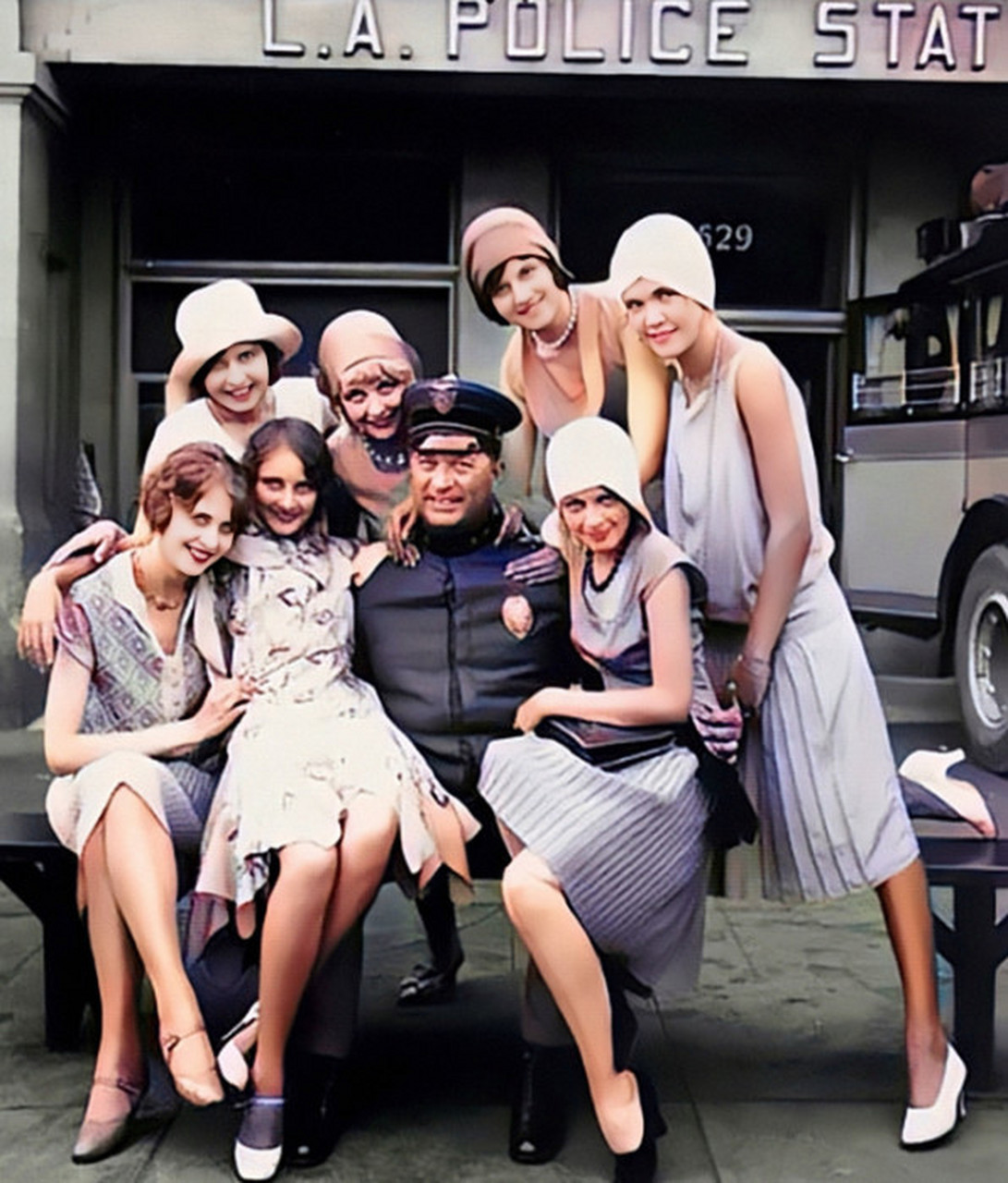 1922年,美国,一群美女簇拥在一名警察,看样子不像是剧照,他也不是沙滩