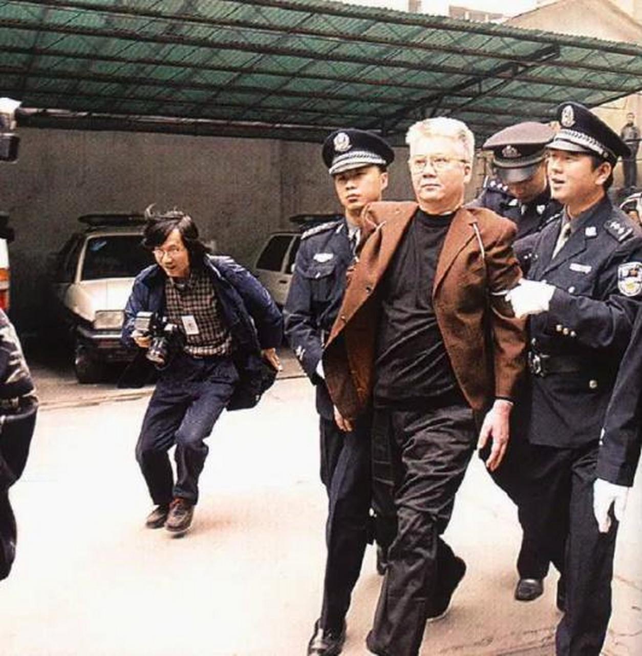 2003年,胡启能被押赴刑场时,一张罕见的镜头,照片中的他头发花白,本该