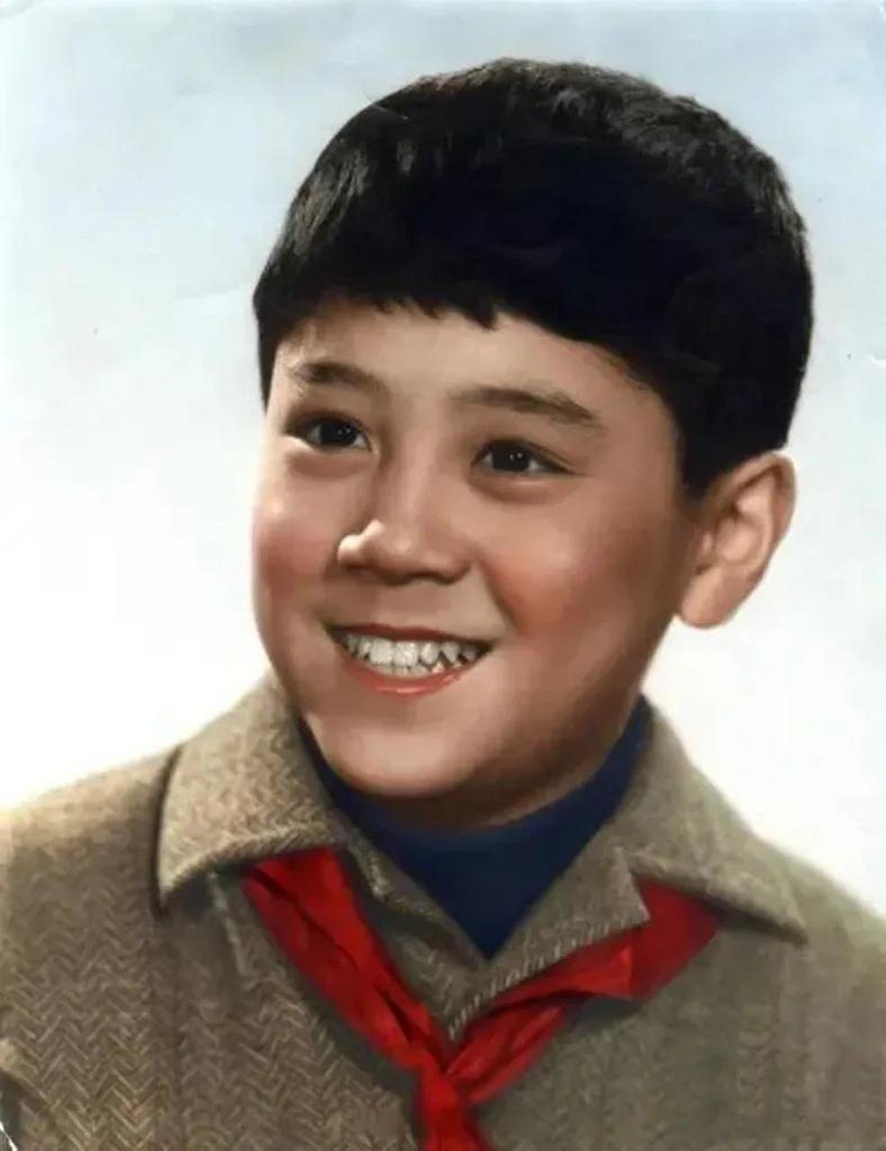 这是一张上世纪70年代的青年照片,他戴着一块红领巾,脸上化了妆容