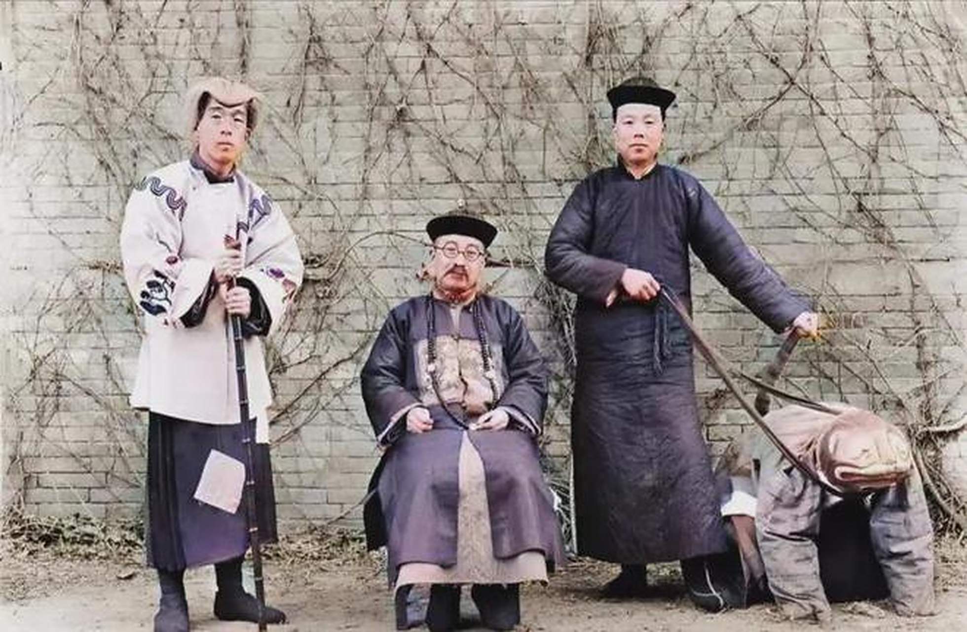 一张清末时期的老照片展示着一个坐在凳子上的官老爷,他戴着眼镜,神情