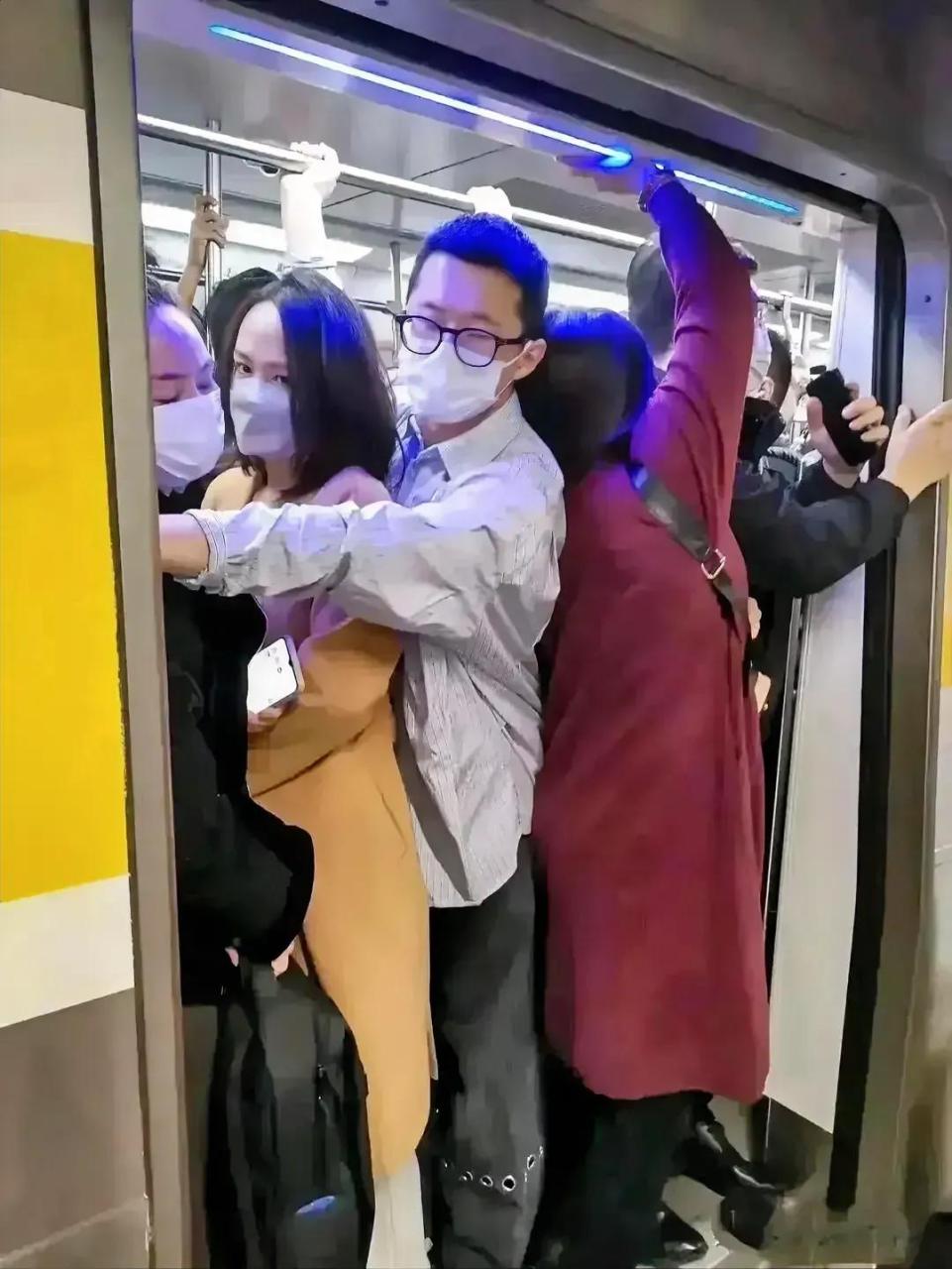 地铁拥挤,黄衣女士,从表情可以看出,她显得很尬尴,也显得很无奈.