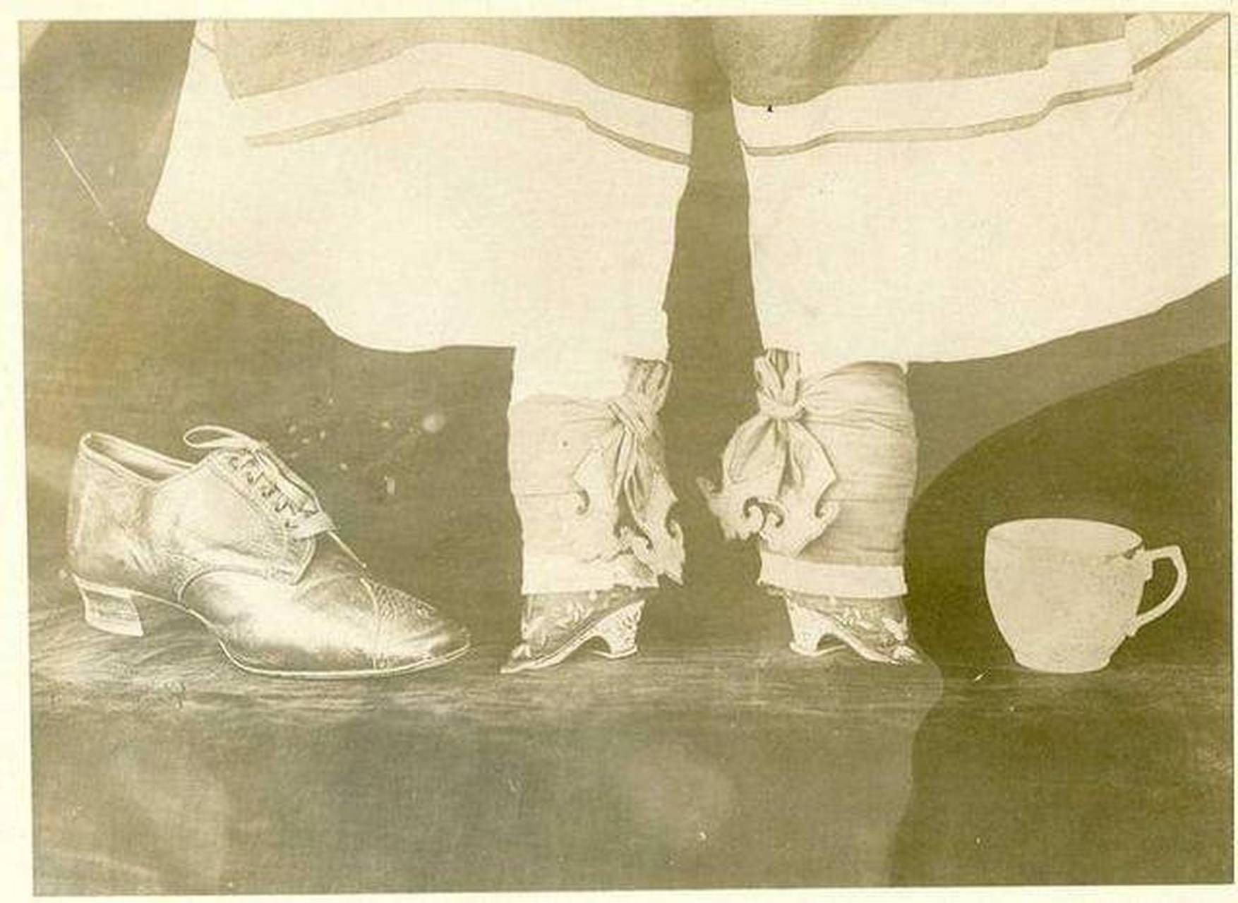 清朝年间,一名缠足的女子坐在自己的卧床上,解开层层的裹脚布透气.