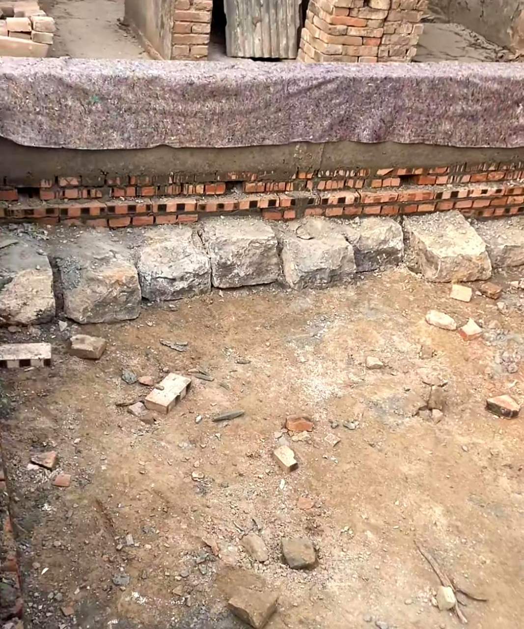 村里有一家人在盖房子时,在地基下面铺了大石头,不知道这样做是否能