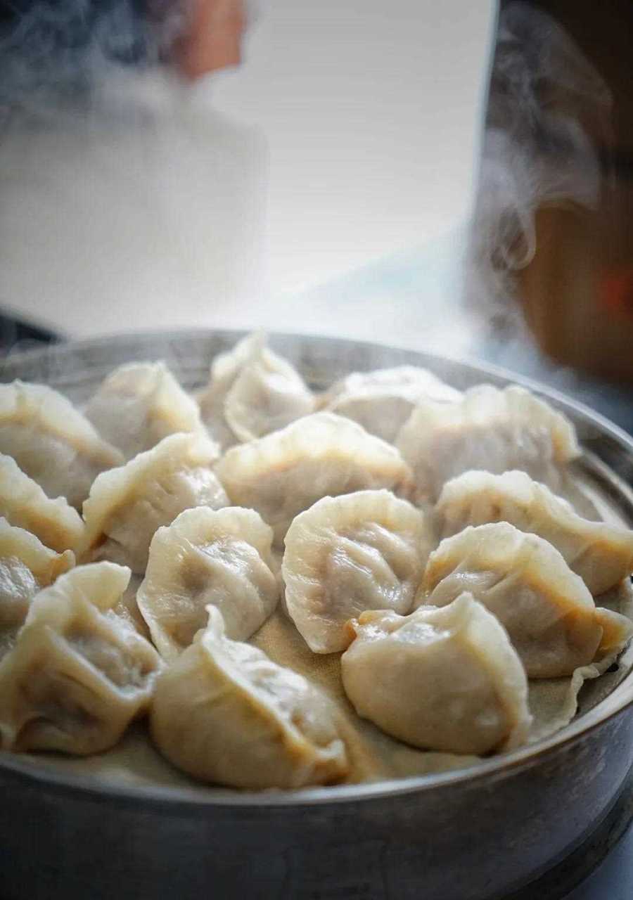 用筷子小心翼翼把牛肉蒸饺夹到小碟里,[得意] 倒上陈醋和些许的辣子油