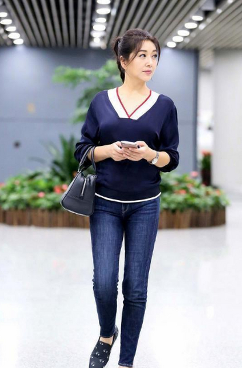 52岁的江珊罕见穿紧身牛仔裤,配v领针织衫现机场, 在某次机场出行时