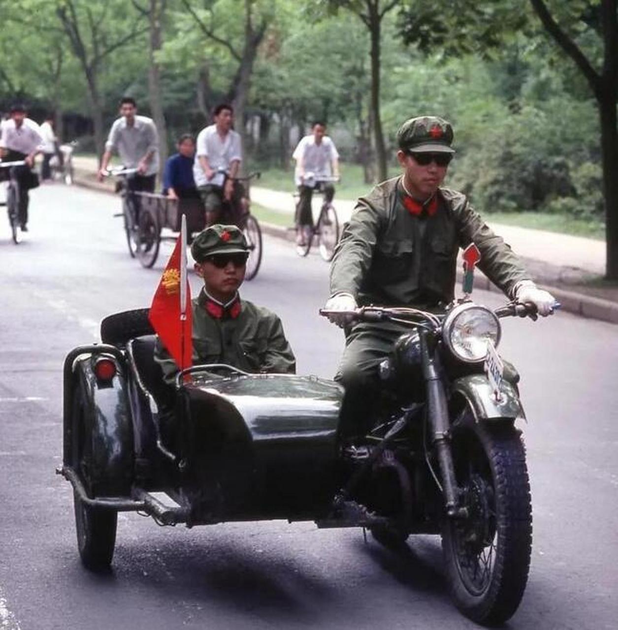 他们身着类似解放军的服装,骑着边三轮.