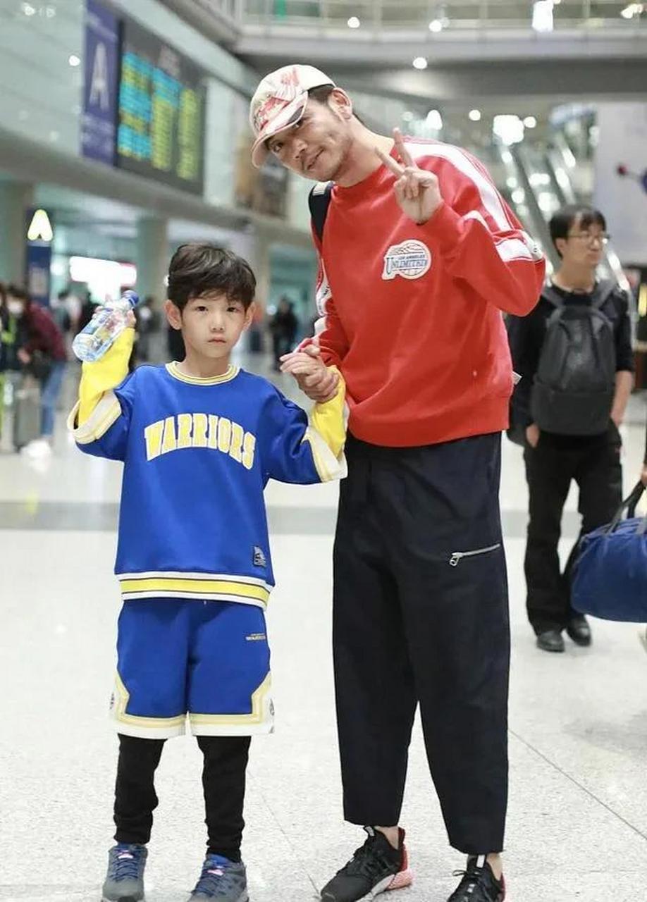 杨烁一身休闲街头范儿,穿橘红色卫衣 黑色休闲长裤,看起来宽松舒适