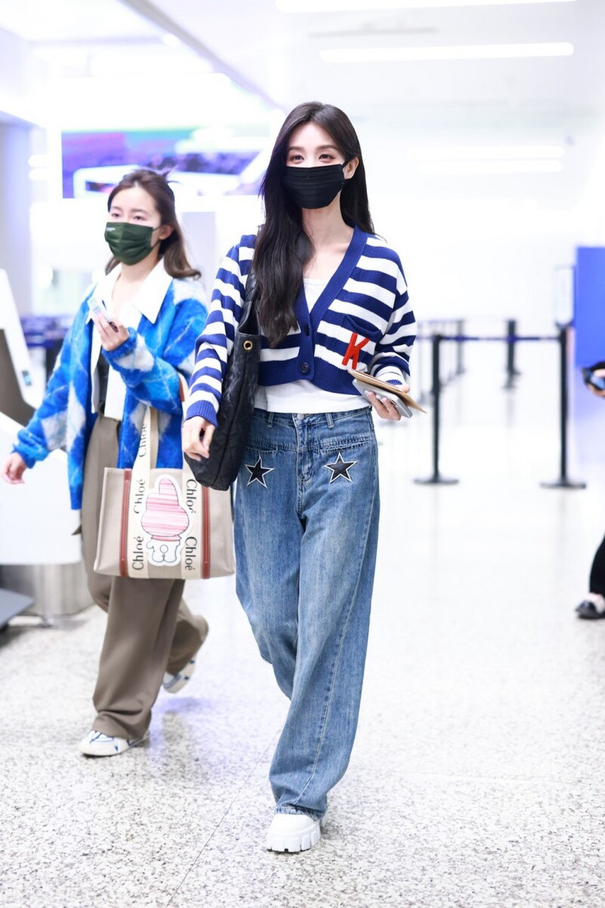 李一桐机场街拍,身穿条纹开衫搭配牛仔阔腿裤,圣罗兰手袋休闲时尚