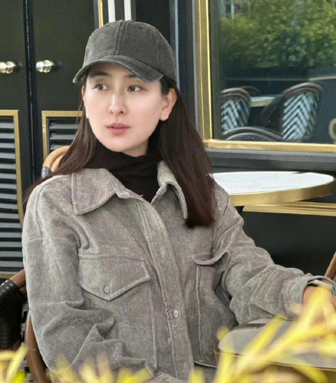 马苏素颜坐在街边小店旁边发呆,她的皮肤状态还是不错的,看着很通透.