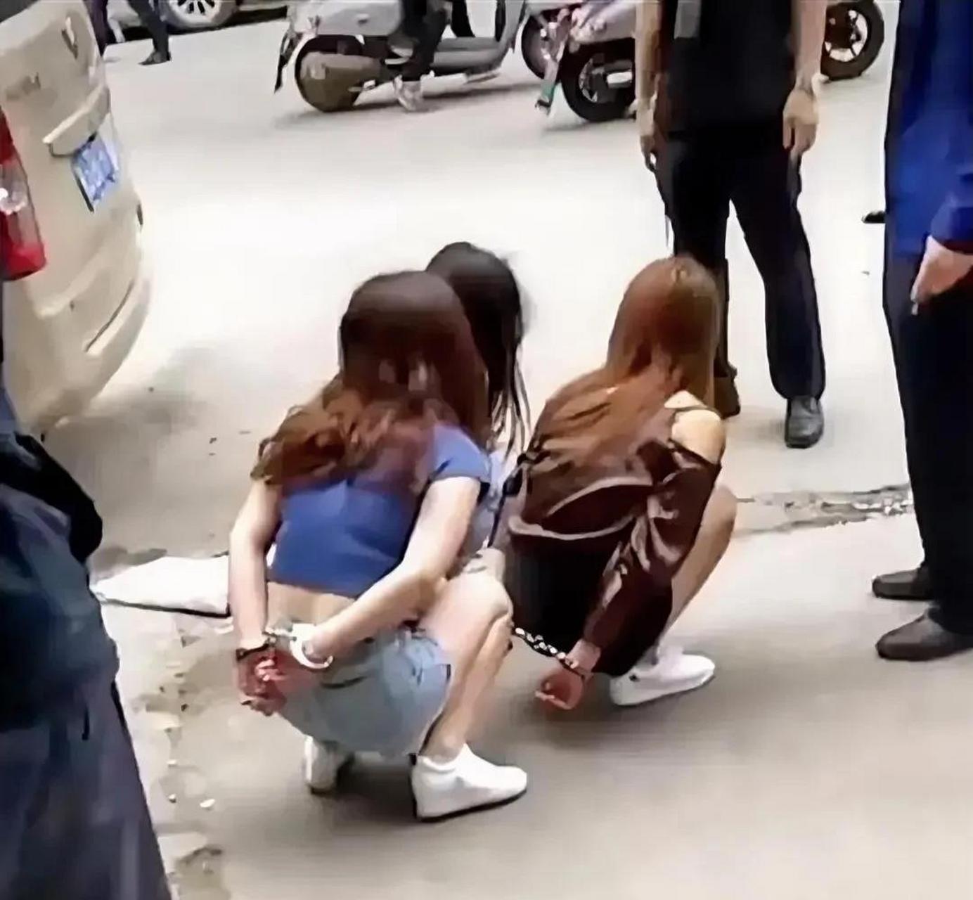 照片上是三个年轻的姑娘,被手铐反铐着双手,蹲在地上的情景.