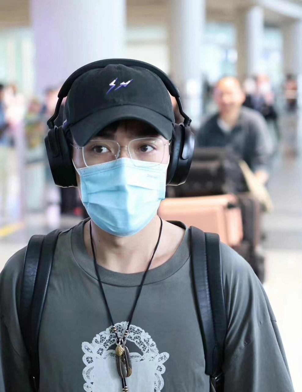 朱一龙返回祖国,戴着一顶黑色棒球帽,身穿印花t恤,展现出清新而又